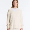 Swetr z dzianiny typu cable knit z dekoltem w serek, wykonany w 100% z bawełny